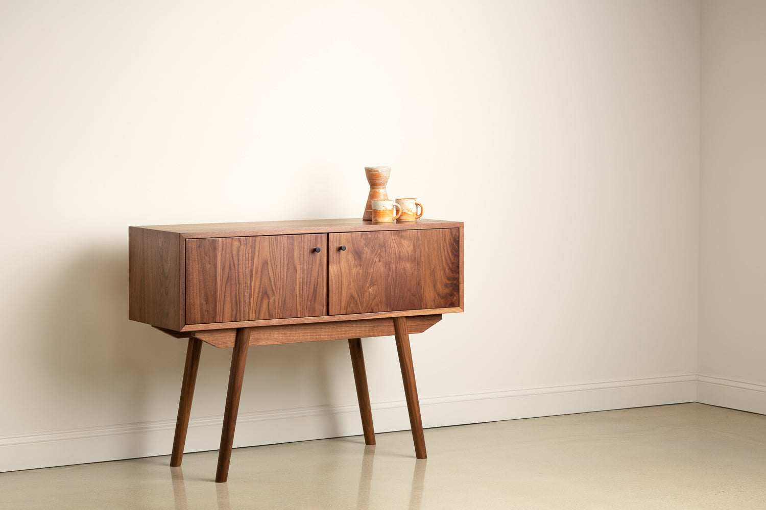 Fjord Large Sideboard in walnut with white and orange coffee mugs on top