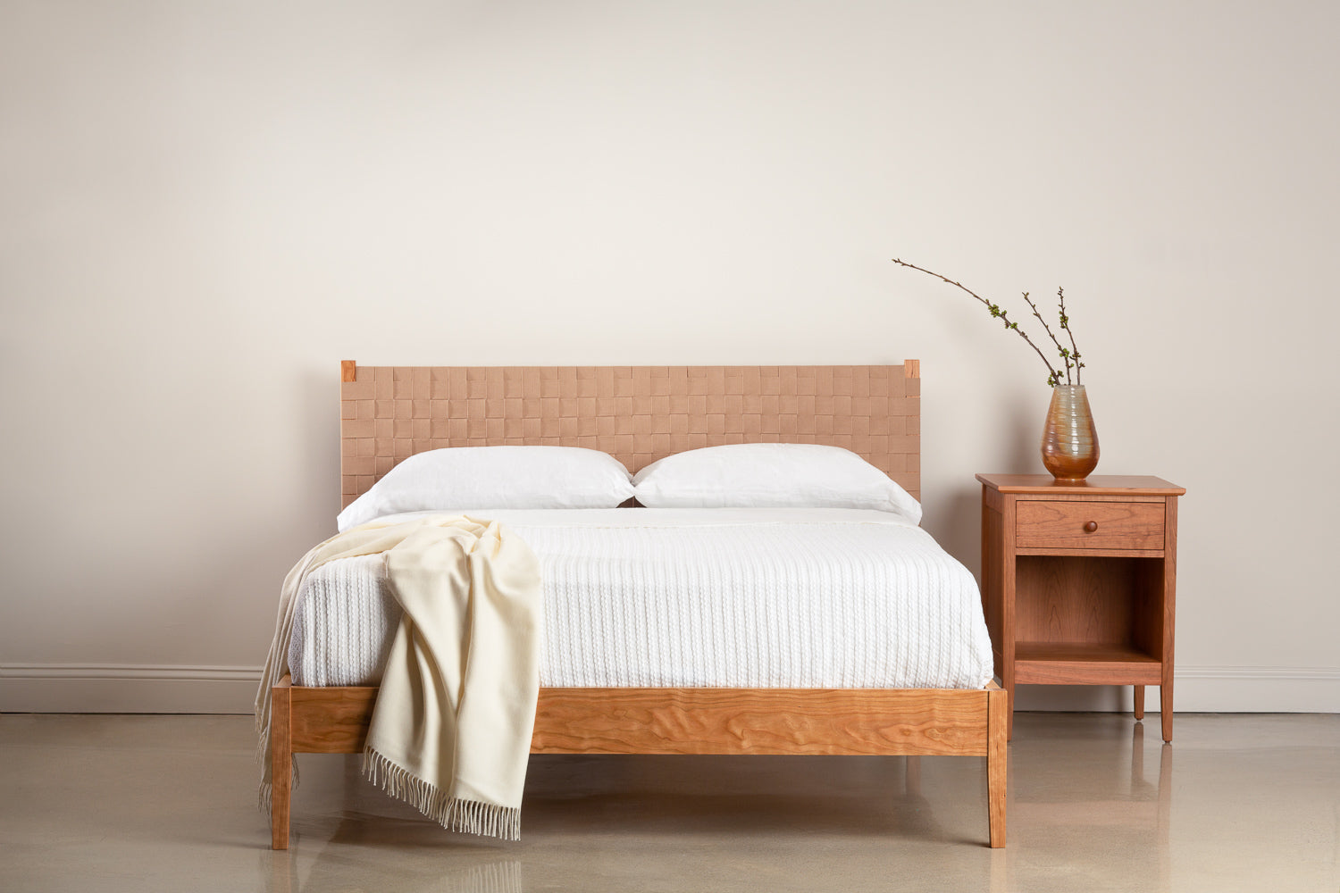 Shaker style bed with woven headboard with nightstand in cherry