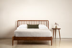 Modern Spindle bed in walnut wood with three legged Mysa Nightstand
