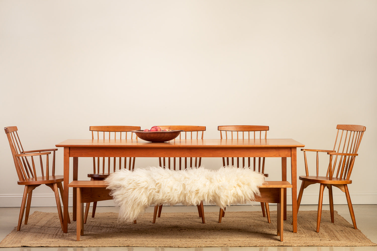 Solid wood dining set with white sheepskin throw on bench
