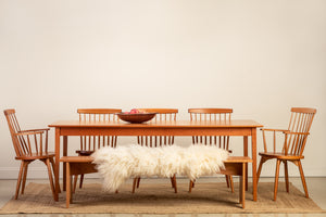 Solid wood dining set with white sheepskin throw on bench