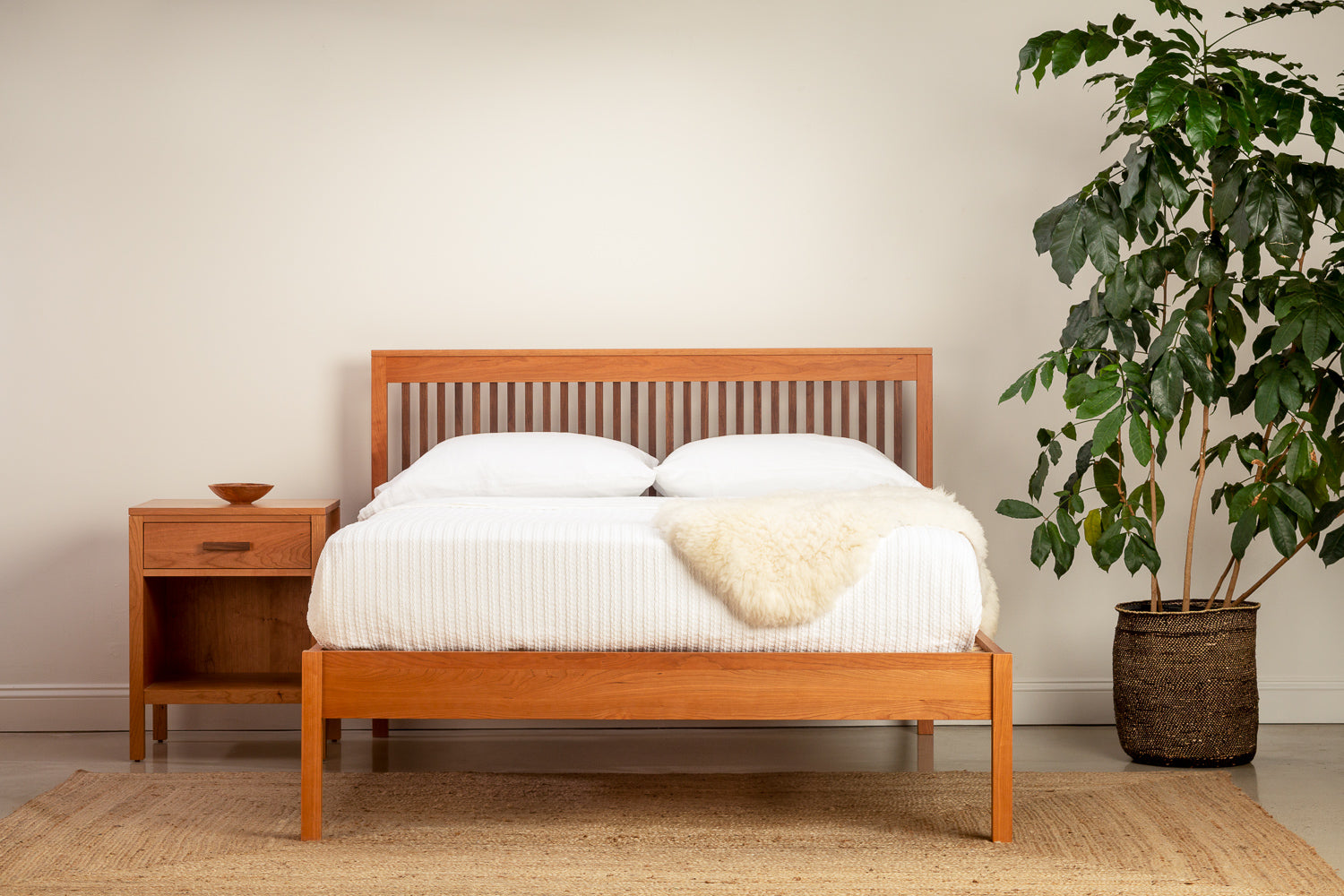 Bedroom with Sunday River Bed and Nightstand in solid cherry and walnut woods with white bedding and tree in corner