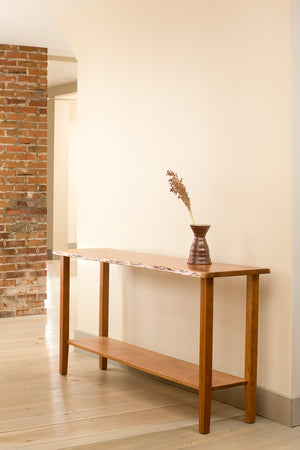 Acadia Live Edge Sofa Table in cherry near brick wall