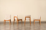 Four cherry Metro Chairs with grey fabric cushions showing the chair at four different angles