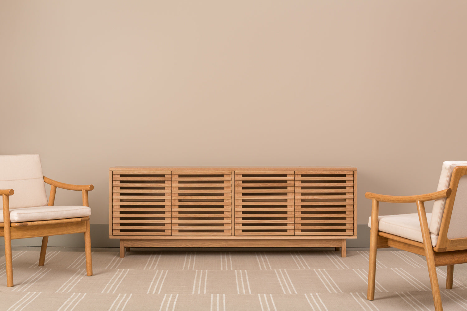 Modern minimalist living room with white oak Upland Media Stand and two Nautilis Loung Chairs for furniture, styled with tan rug