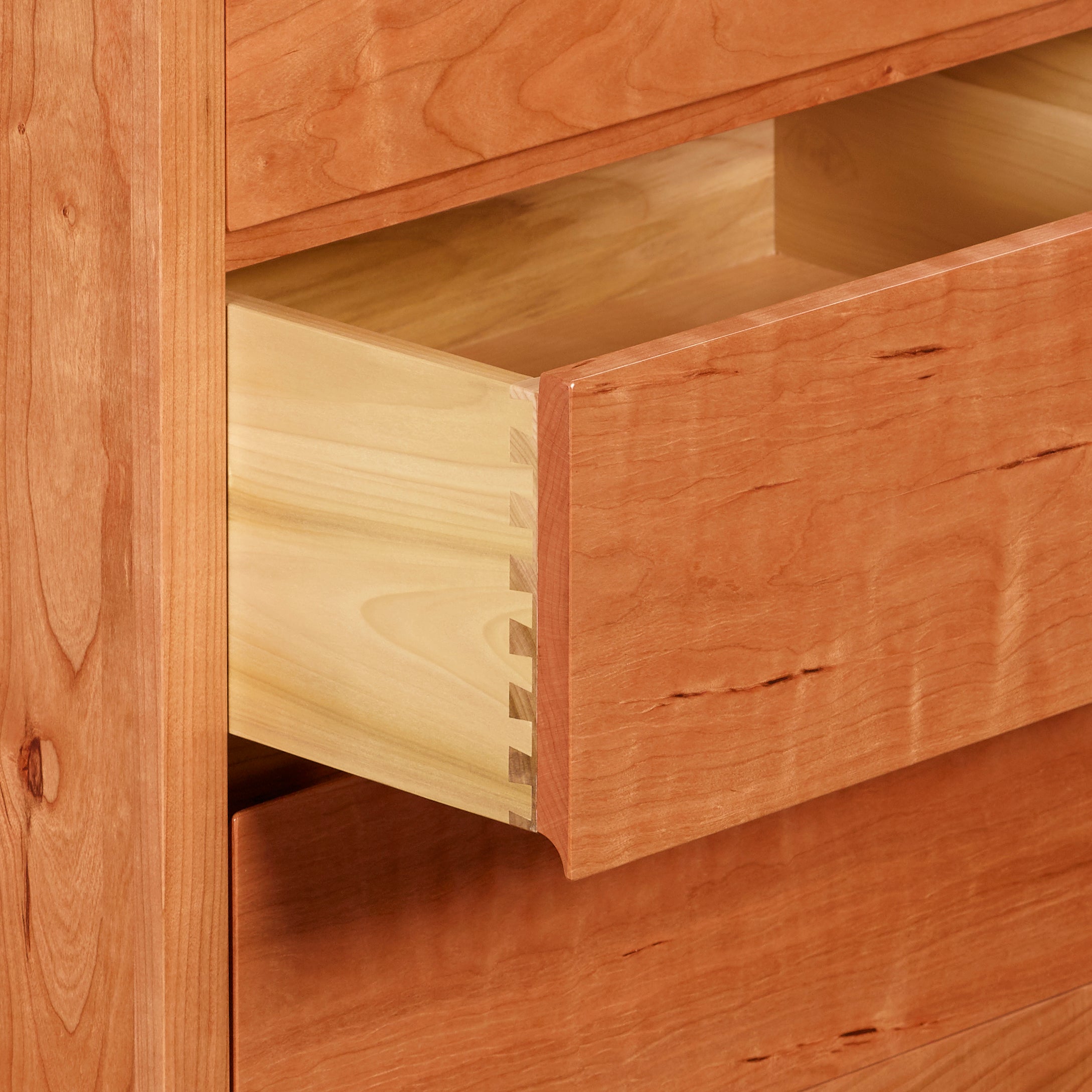 Open drawer of cherry Acadia bedroom storage chest showing dovetail joinery