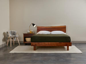 Bedroom furnished with Acadia nightstand, live edge bed in walnut, maple bistro chair and cozy styling