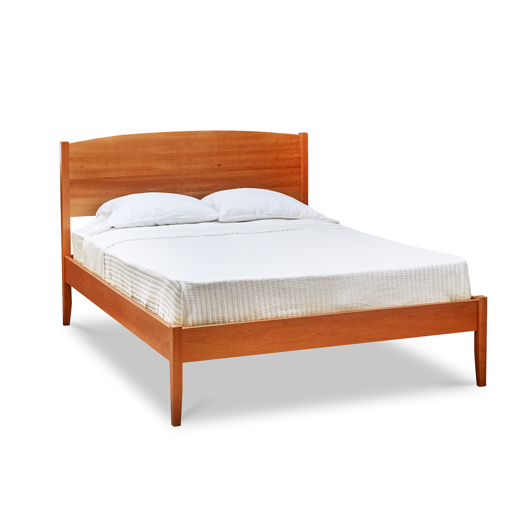 Shaker style, handmade solid cherry wood bed, with arched top and tapered legs, from Maine's Chilton Furniture Co.