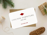 White Chilton Furniture gift card on brown envelope with string and pine cones scattered around