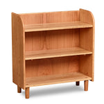 Bookshelf with open top, rounded corners, and round tapered legs, in cherry wood. 