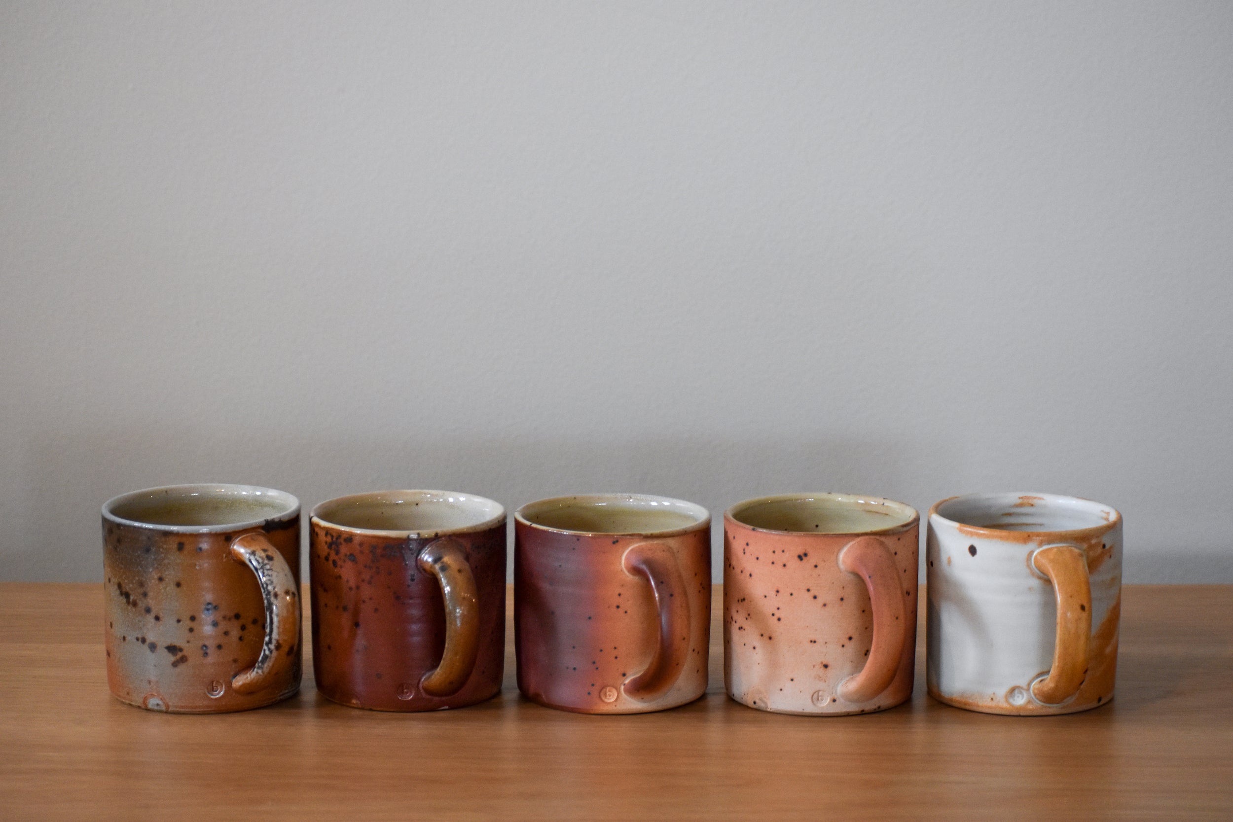 Five speckled, ceramic mugs in various colors
