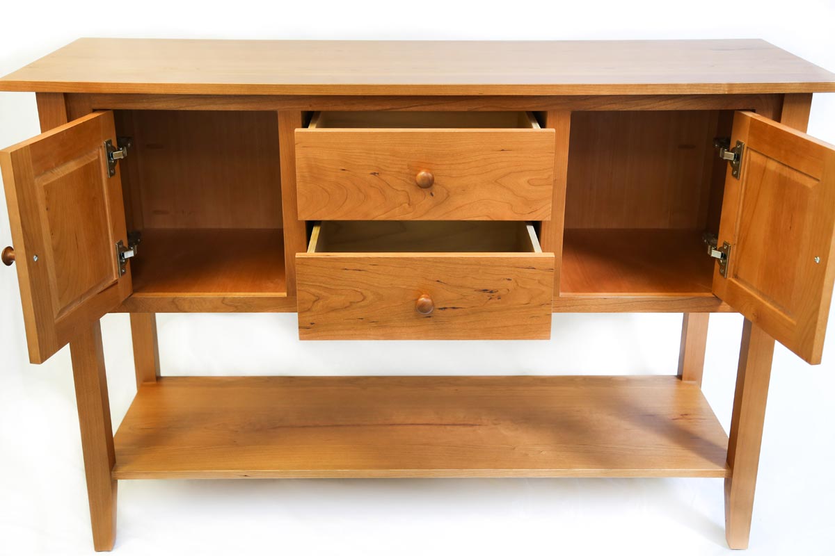 Shaker style huntboard furniture made of cherry wood, with drawers and doors open to show storage space inside 
