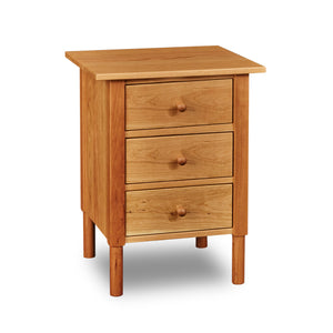 Modern interpretation of a classic Shaker style nightstand with three drawers and rounded legs, in solid cherry wood