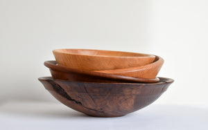 Stack of wooden walnut, cherry, oak and maple bowls