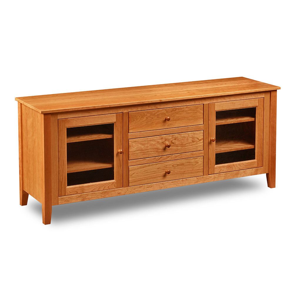 Cherry wood Salmon Falls Media Console with three centered drawers and glass doors with storage shelves behind on both sides