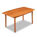 Cherry wood dining table with curved boat-shaped edges and clean tapered legs, from Maine's Chilton Furniture