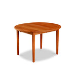 Cherry wood extension table with simple Shaker legs and round top from Maine's Chilton Furniture Co.