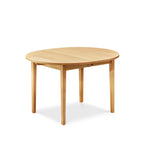 Closed solid maple wood extension table with one leaf with tapered Shaker legs and oval top from Maine's Chilton Furniture Co.
