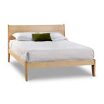Modern sleigh bed in maple with low profile and white bedding, from Maine's Chilton Furniture Co. 