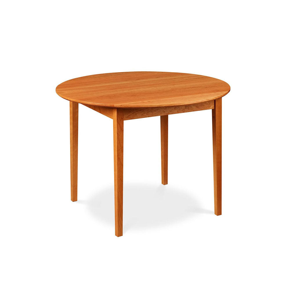 Small Shaker style dining table with tapered legs and round top, made of cherry wood